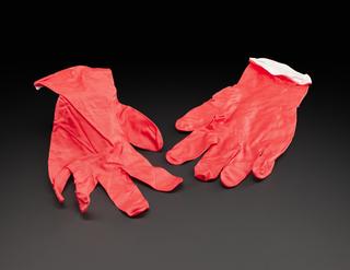 Red gloves worn as PPE by people testing COVID-19 samples
