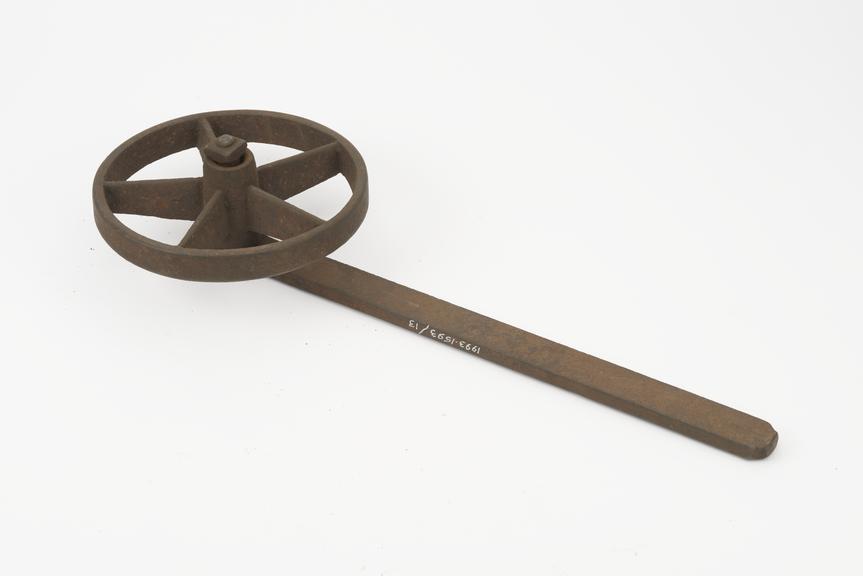 Iron wheel running on a pin on the end of an iron arm