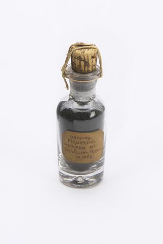 Mauveine acetate dye in microcrystalline form in a cork-stoppered glass bottle